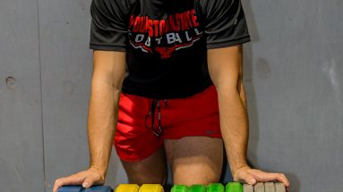 Sports Massage Therapist posing next to some weights plates